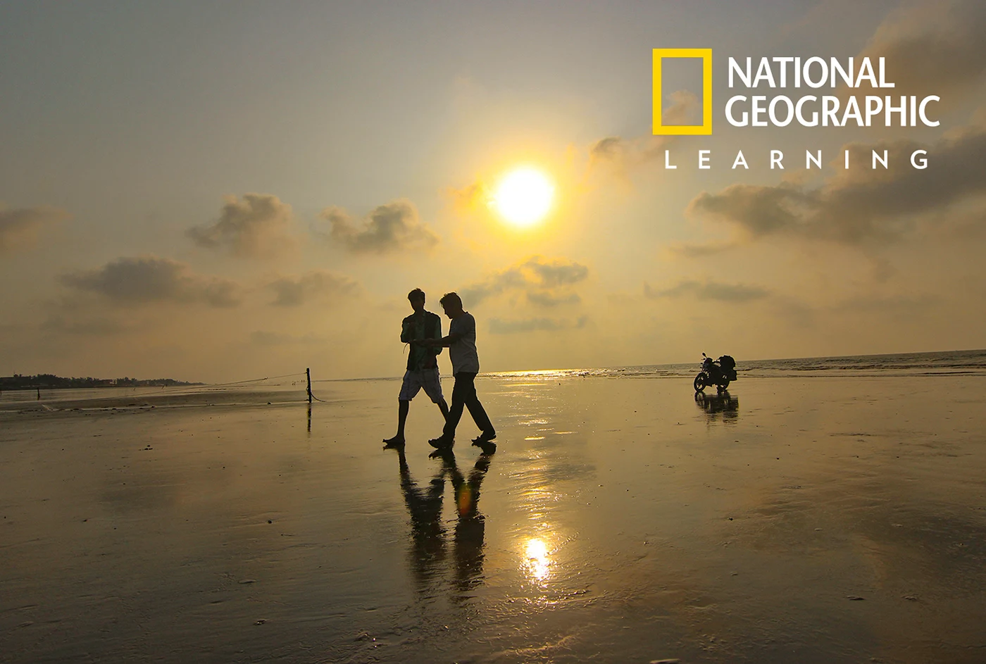 People walking along the shoreline at sunset in Mandarmoni, West Bengal