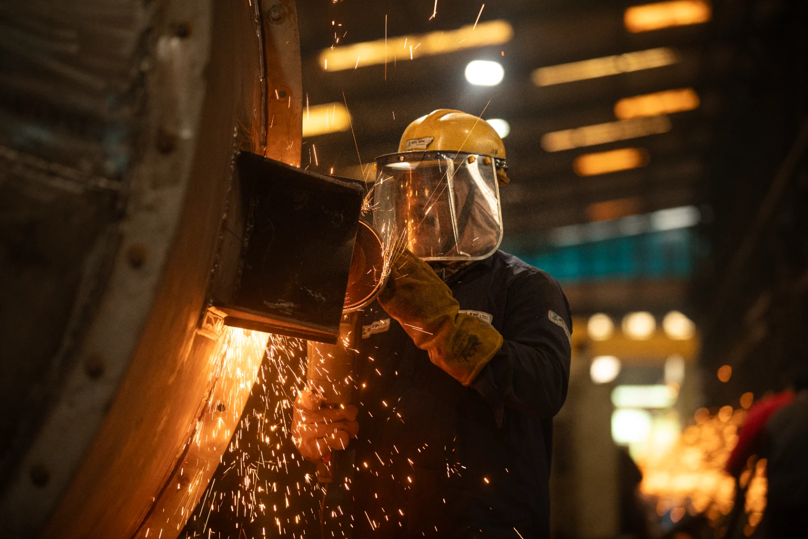 Industrial worker welding inside a manufacturing facility, captured for BTL EPC Ltd.'s corporate profile